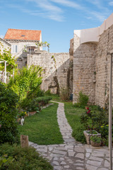 Fototapeta na wymiar Courtyard of a house with a garden and a plant with walls, in stone, in Dubrovnik, Croatia, Europe.