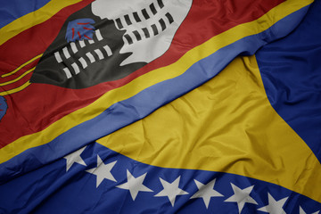 waving colorful flag of bosnia and herzegovina and national flag of swaziland.
