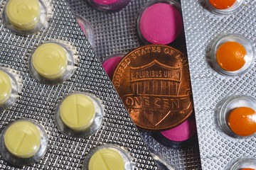 One us cent coin is among the packages of colored tablets