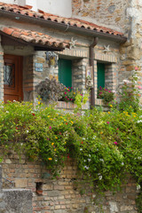 Obraz na płótnie Canvas Details of the windows and the brick walls of an ancient house, old town, Grado, Gorizia, Italy