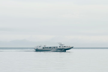 Fast soviet hydrofoil boat goes on Baikal lake at foggy summer day