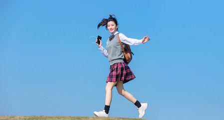 Fototapeta na wymiar Asian female students against blue sky background