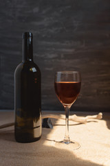 Glass of red wine in arched sunlight on the sand.