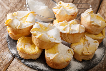 Soffioni cupcake with ricotta cheese sprinkled with powdered sugar close-up on a slate board....