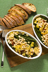 Cannellini nutritious white bean salad with green beans, sun-dried tomatoes and artichokes in oil. Traditional italian food