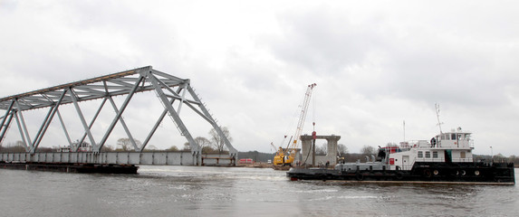 Fototapeta na wymiar River Tug carries part of the bridge on a barge