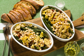 Cannellini nutritious white bean salad with green beans, sun-dried tomatoes and artichokes in oil. Traditional italian food