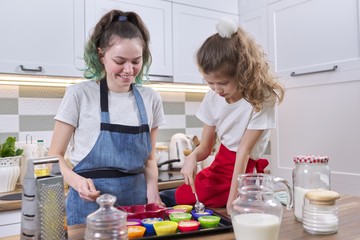 Children two girls sisters preparing muffins in home kitchen