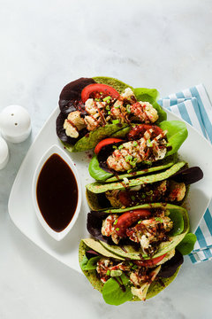 gluten-free vegan green tachos made from chickpea flour with spinach and toppings from baked cauliflower and lettuce with sweet and sour sauce based on soy sauce.