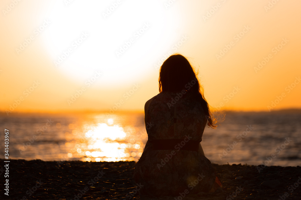 Wall mural silhouette of a woman sitting during a sunset