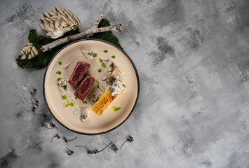Barbecue dry aged beef fillet medallion steak natural with fried herbs and capers as closeup on a modern design plate with copy space