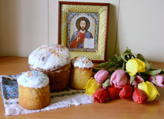 
Easter day. On the table is an icon, cakes, a bouquet of beautiful, colorful tulips.