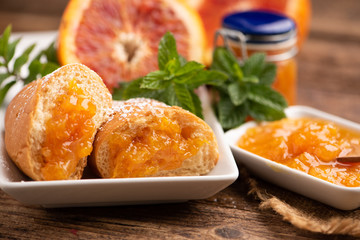 Bowl with orange marmalade and croissants