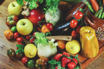 rustic composition of fruit and vegetables on wooden table illuminated by a warm light