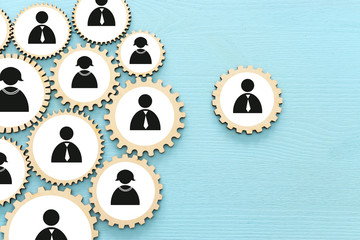 image of cog wheels puzzle blocks with people icons over wooden table ,human resources and...