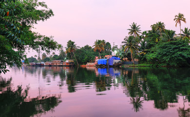 Boats on the riverbank of the backwaters in Allepey, Kerala at sunset, India.