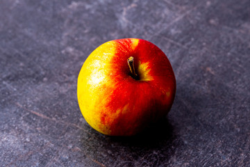 Single fresh apple against scratched black texture