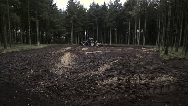 After mulching the scarifier is preparing the forest soil. This is a long shoot of a scarifier that drive by while working the soil.
