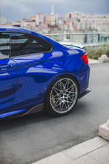 Parking blue sedan outdoor,back wheel and door view