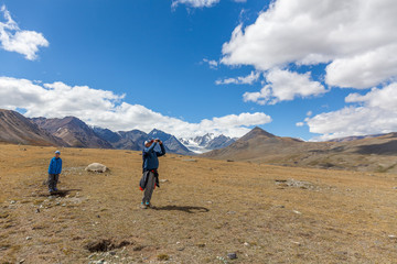 Fototapeta premium Hiker young man and boy in the Altai mountains of Mongolia. Enjoy the scenery and take pictures of it.