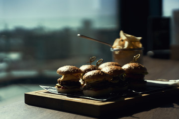 Craft beef burger and french fries on wooden table isolated on black background. Hamburgers and French fries on the wooden tray. - 341417916