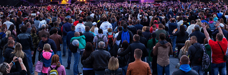 silhouettes of concert crowd in front of bright stage lights.