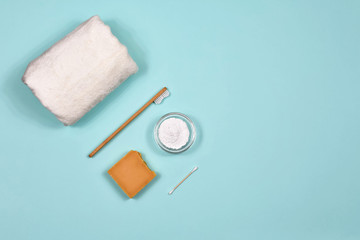 Fototapeta na wymiar Zero waste concept. Toothbrush, tooth powder, towel and soap on a blue background. Eco-friendly bamboo toothbrush. View from above.