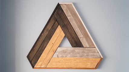 Decorative wooden wall coating of triangle shape tiles in the color of various trees. Interior wooden design element.