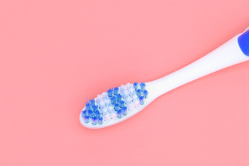 White toothbrush with red swirl of toothpaste on pink background . Dental and healthcare concept .