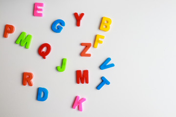multicolored children`s english alphabet scattered on a white background