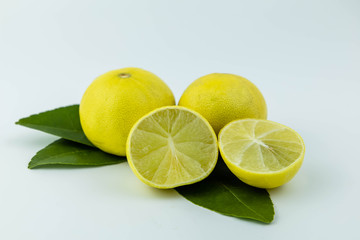 Natural fresh lemon, sliced in half and green leaves, isolated on a white background