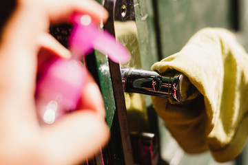 Limpeza da maçaneta da porta com álcool gel.