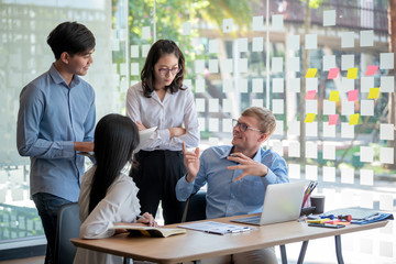 Teamwork of Asian business people discussing documents and plan financial graph analysis in the meeting room.