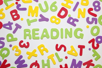 word - reading - and seamless pattern with letters of the alphabet and numbers in random order on a white background. Education and Back to school concept