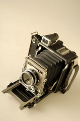 An old vintage 1940s bellows film camera with a sephia tone.