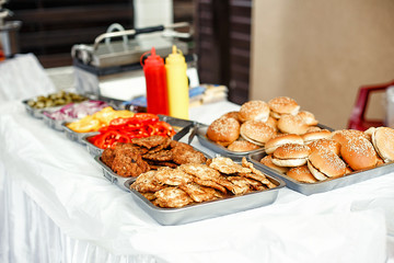 Street food for sale. Fresh vegetables fried meat in containers. Burger ingridients set background. Selective focus