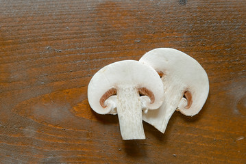 Fresh champignon mushrooms on wooden table, closeup. Space for text