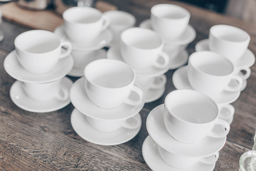 Stacked empty teacups with teaspoons at a function over