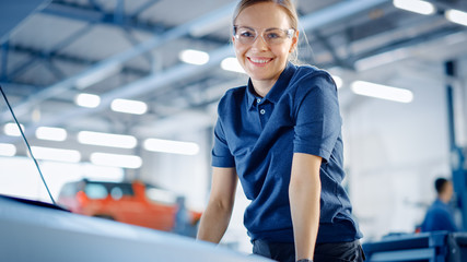 Beautiful Empowering Female Car Mechanic is Posing in a Car Service. She Wears Safety Glasses....