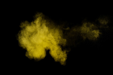 Yellow powder explosion on black background. Colored powder cloud. Colorful dust explode. Paint  Holi.