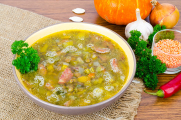 Soup from pumpkin, lentil and sausage. Photo