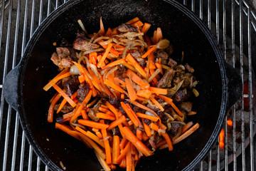 Pieces of lamb with onion are fried in boiling oil on the fire. As a stage in the preparation of...