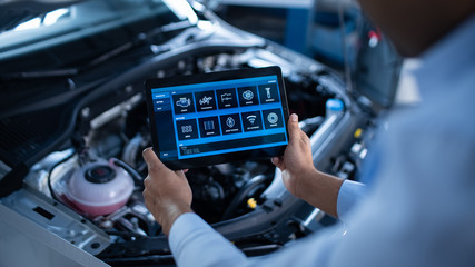 Car Service Manager or Mechanic Uses a Tablet Computer with a Futuristic Interactive Diagnostics...