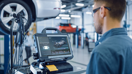 Car Service Manager or Mechanic is Running an Interactive Diagnostics Software on an Advanced...