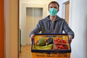 Lebensmittellieferung von Obst und Gemüse in Corona Krise vor die Haustür mit Schutzmaske wegen...