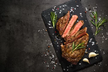 Rolgordijnen Grilled beef steak on black table. © nadianb