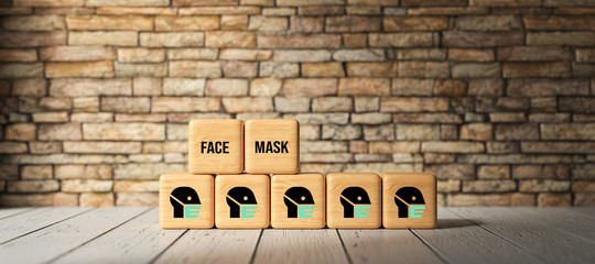 Fototapeta na wymiar cubes with message FACE MASK in front of a brick wall background