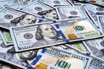 One hundred US dollar bills. Many banknotes are scattered. A pile of bills of American dollars....