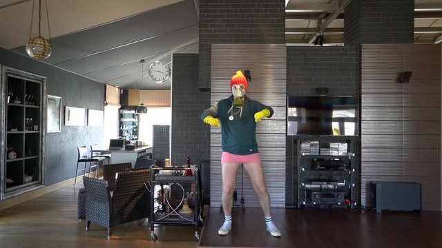 Frick - a young guy at home in a gas mask and yellow rubber gloves dances and fools around in underwear in his underpants. Funny funny guy, weird unusual sexy guy. Bored in the house, for tiktok