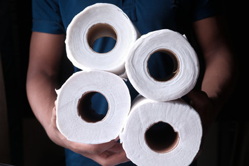 man hand holding roll of toilet paper 
